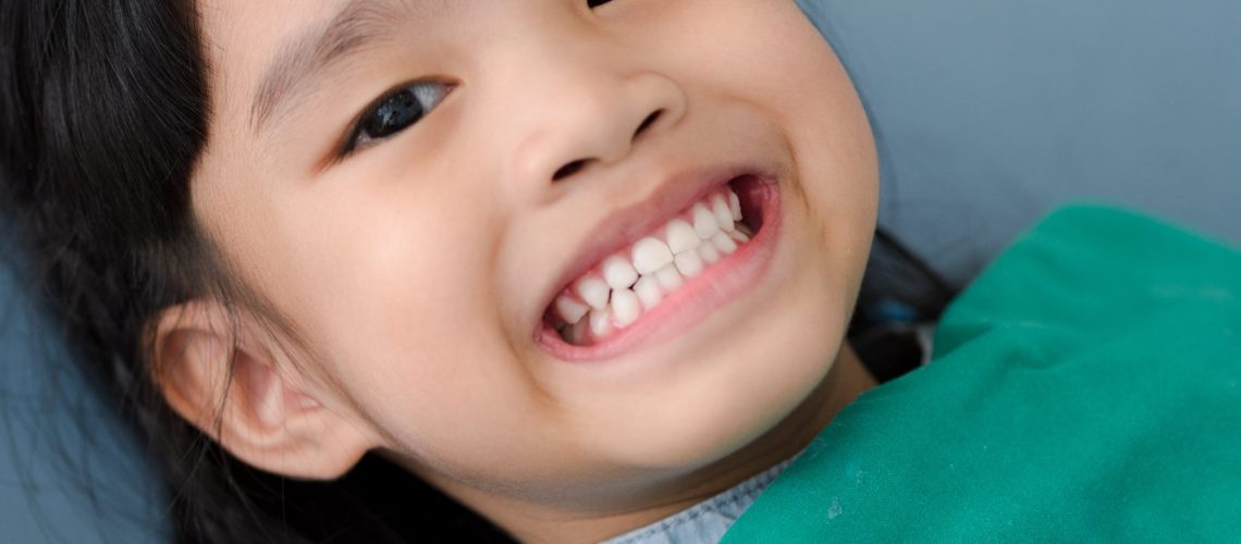 little girl patient teeth on white at the dentist's office