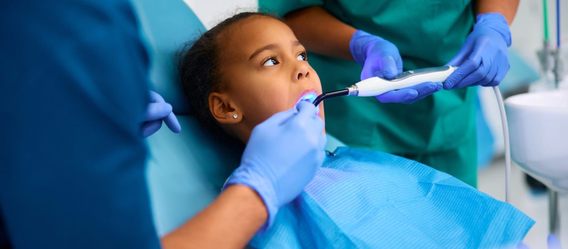 black little girl during dental procedure at dentist's office.